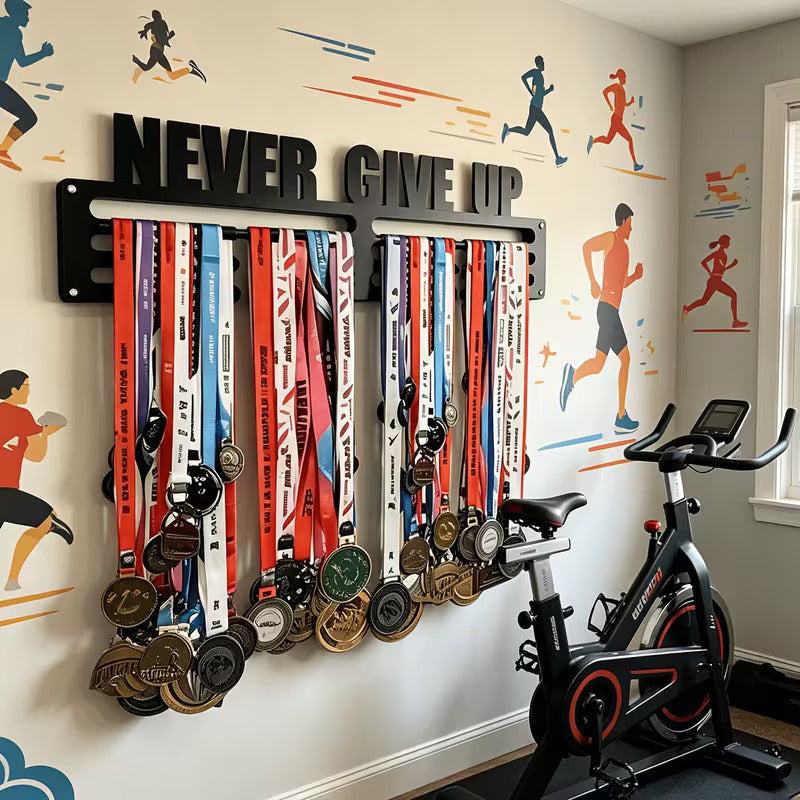 Never Give Up medal hanger on wall with runner mural, next to spin bike